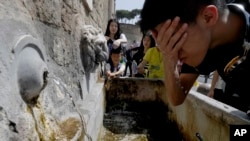 Para turis mendinginkan diri di sebuah air mancur di Roma, Italia, akibat cuaca panas ekstrem bulan Agustus tahun lalu (foto: ilustrasi). 