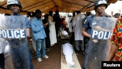 FILE - Security forces stand guard near the bodies of protesters, killed during a rally, in Conakry, Guinea, Oct.2, 2009.