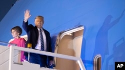 U.S. President Donald Trump and first lady Melania Trump wave as they board Air Force One upon departure from Indian Air Force Palam airport in New Delhi, India, Feb. 25, 2020.