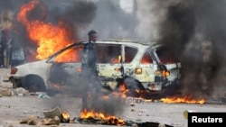 FILE - A protester looks on near a burning barricade during a "national shutdown" against the election outcome in Maputo, Mozambique, on Nov. 7, 2024.