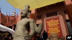 FILE PHOTO - The head of Male Divinity statue, right, and other artifacts are on display during a ceremony after the artifacts were returned back from Norwegian collector Morten Bosterud, at Cambodian National Museum in Phnom Penh, Cambodia, Tuesday, Oct. 20, 2015. 