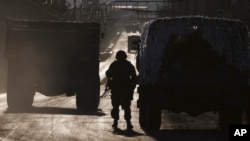 An Ukrainian soldier stands next to a broken down vehicle outside Artemivsk, Ukraine, as troops pull out of Debaltseve Feb. 18, 2015.