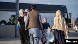 Los refugiados afganos que apoyaron la misión de Canadá en Afganistán se preparan para abordar los autobuses después de llegar al Aeropuerto Internacional Toronto el 24 de agosto de 2021.
