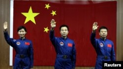 Chinese astronauts Jing Haipeng (C), Liu Wang (R) and Liu Yang, China's first female astronaut, wave to the media during a news conference at Jiuquan Satellite Launch Center, in northwest China's Gansu province, June 15, 2012. 