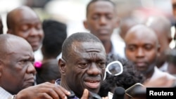 FILE - Uganda's main opposition leader Kizza Besigye (C) speaks to the media in Uganda's capital Kampala, Oct. 4, 2016.