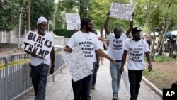 FILE - Supporters of former President Donald Trump with signs and T-shirts that read "Blacks for Trump" gather near the E. Barrett Prettyman U.S. Federal Courthouse, in Washington, Aug. 3, 2023.