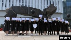 香港中文大学毕业生举起被中国拘押的12名港人的姓名牌子（2020年11月19日）