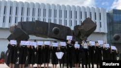 香港中文大学毕业生举起被中国拘押的12名港人的姓名牌子。（2020年11月19日）