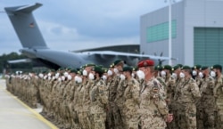 German soldiers line up for the final roll call in front of a German armed forces Bundeswehr Airbus A400M cargo plane after returning from Afghanistan at the airfield in Wunstorf, Germany, June 30, 2021.