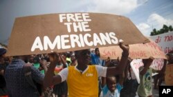 Para pengunjuk rasa menuntut pembebasan 17 warga AS dan Kanada, yang tergabung dalam sebuah kelompok misionaris Kristen, yang diculik oleh geng kriminal di Haiti, dalam sebuah aksi protes di Port-au-Prince pada 19 Oktober 2021. (Foto: AP/Joseph Odelyn)