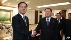 South Korean Unification Minister Cho Myoung-gyon, left, shakes hands with the head of North Korean delegation Ri Son Gwon after their meeting at the Panmunjom in the Demilitarized Zone in Paju, South Korea, Jan. 9, 2018. 