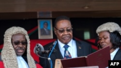 Le président Mutharika prête serment en présence du juge en chef Andrew Nyirenda (à gauche) et du greffier de la Cour suprême d'appel Agnes Patemba (à droite) à Blantyre, le 28 mai 2019. L'élection a été par la suite annulée à cause des irrégularités. (Photo AMOS GUMULIRA / AFP)