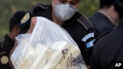 FILE - A drug police agent carries a bag of cocaine packages to be incinerated in Guatemala City, April 23, 2008. 