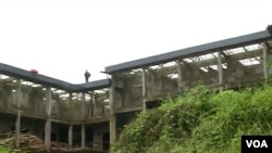 People walk on an abandoned public building in Buea, Cameroon, Aug. 1, 2019. (Moki Kindzeka/VOA) 