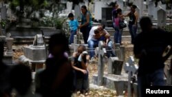 People grieve during the funeral of Javier Rivas, one of the inmates who died during a riot and fire in the cells of the General Command of the Carabobo Police, at the cemetery in Valencia, Venezuela, March 29, 2018.