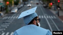 Seorang lulusan program pascasarjana dari Universitas Columbia tampak di kampusnya sehari sebelum upacara wisuda, yang akan diadakan secara daring karena pandemi COVID-19 di Manhattan, New York, 15 Mei 2020. (Foto: Reuters) 