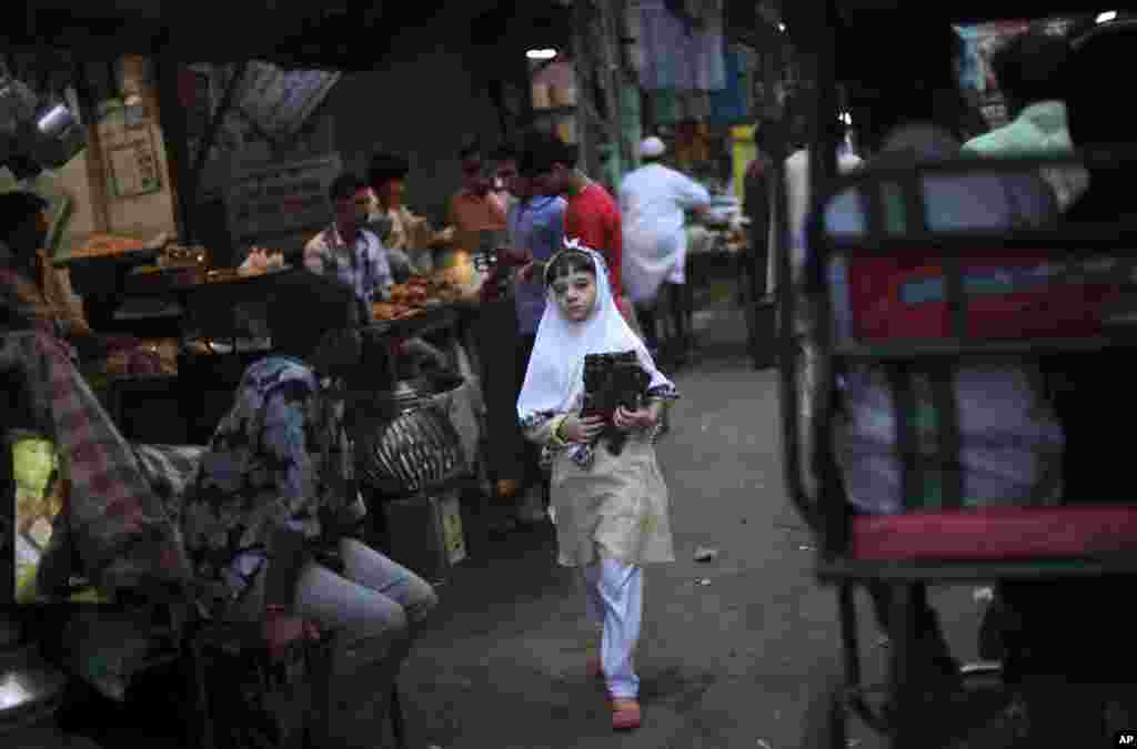 A young Muslim girl walks with a copy of the holy Quran on International Day of the Girl Child in New Delhi, India, October 11, 2012. 