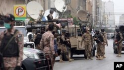 Security personnel surround the Stock Exchange Building after it was attacked by gunmen, in Karachi, Pakistan, June 29, 2020.