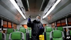 FILE - A worker disinfects a public bus against coronavirus in Tehran, Iran, Feb. 26, 2020. 