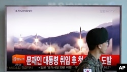 A South Korean army soldier walks by a TV news program showing a file image of missiles being test-launched by North Korea, at the Seoul Railway Station in Seoul, South Korea, May 14, 2017.