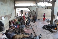 FILE - Survivors of Cyclone Idai wait in an abandoned and derelict building near Nhamatanda, about 50 kilometers from Beira, in Mozambique, March, 22, 2019.