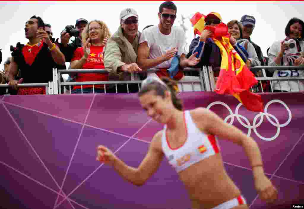 Para penggemar menyemangati Elsa Baquerizo McMillan dari Spanyol di tengah-tengah pertandingan penyisihan bola voli pantai melawan Argentina.