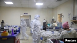 FILE - Medical staff dressed in protective suits treat coronavirus disease patients at the COVID-19 ICU of Machakos Level 5 Hospital, in Machakos, Kenya, Oct. 28, 2020.