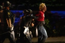 Portland police make arrests on the scene of the nightly protests at a Portland police precinct on Sunday, Aug. 30, 2020 in Portland, Ore. Oregon State Police will return to Portland to help local authorities after the fatal shooting of a man…