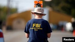 FILE - An FBI agent investigates the site of the shooting at the First Baptist Church of Sutherland Springs, Texas, Nov. 7, 2017. 