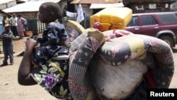 A woman carries her child in Minova, 45 kilometers west of Goma, DRC, November 26, 2012. 