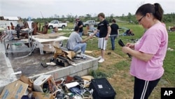Carla Arendal looks at some jewelry she salvaged from her home after a tornado destroyed the building in Vilonia, Arkansas, April 26, 2011