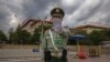 FILE - A Chinese People's Liberation Army soldier gestures to the photographer to stop taking photos in front of the Great Hall of the People, after the second plenary session of China's National People's Congress, in Beijing, May 25, 2020.