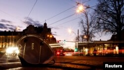 FILE - A protective mask against COVID-19 lies in a street as cars pass in Vienna, Jan. 6, 2022.
