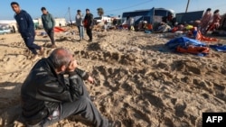 Displaced Palestinians check their belongings in a tiny coastal area of a territory named Al-Mawasi after Israeli tanks reportedly raided the sector, west of Khan Yunis, in the southern Gaza Strip on Feb. 21, 2024, amid the ongoing war between Israel 
