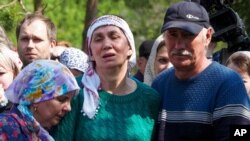 Relatives mourn during the funeral of Elvira Ignatieva, a teacher who was killed in a shooting at a school on Tuesday, in Kazan, Russia, May 12, 2021. 