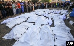 Los palestinos se reúnen mientras lloran por los cuerpos de los muertos en el bombardeo israelí en Deir Balah, en el centro de la Franja de Gaza, en el hospital Shuhada Al-Aqsa de la misma ciudad el 6 de noviembre de 2023. ​