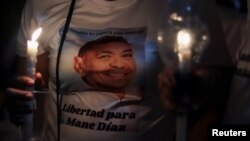Una persona sostiene velas mientras la gente asiste a una vigilia exigiendo la liberación del padre del delantero del Liverpool FC, Luis Díaz, después de ser secuestrado, en Barrancas, Colombia, el 31 de octubre de 2023.