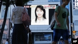 A portrait of Japanese journalist Mika Yamamoto is shown on a large monitor screen in Tokyo Tuesday, Aug. 21, 2012 during a TV news broadcast reporting her death in Syria. 