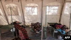 FILE - Patients suffering from cholera receive treatment inside a tent converted into a temporary field hospital near the remote village of Dor, Sudan, April 28, 2017.