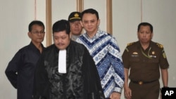 Jakarta Governor Basuki "Ahok" Tjahaja Purnama, center, is escorted by prosecutors as enters the court room for his sentencing hearing in Jakarta, Indonesia, May 9, 2017.