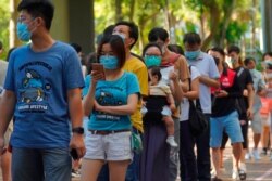 FILE - People queue up to vote in Hong Kong, July 12, 2020, in an unofficial primary for pro-democracy candidates ahead of legislative elections in September.