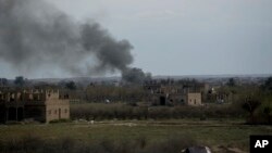 Smoke rises from a strike on Baghuz, the last of the Islamic State group's holdouts in Syria, March 22, 2019. 