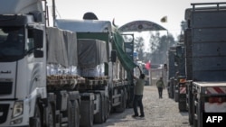 Sejumlah truk yang membawa bantuan untuk warga Palestina di Jalur Gaza bergerak memasuki wilayah tersebut dari Mesir melalui perbatasan Rafah pada 21 Oktober 2023. (Foto: AFP/Eyad Baba)