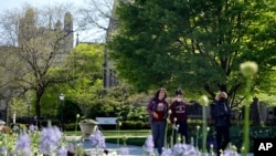 Students wearing masks make their way through the University of Chicago campus, May 6, 2021, in Chicago, Illinois.