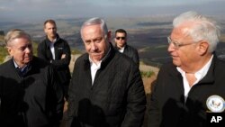 FILE - Israeli Prime Minister Benjamin Netanyahu, center, Republican U.S. Sen. Lindsey Graham, left, and U.S. Ambassador to Israel David Friedman, right, visit the border between Israel and Syria at the Israeli-held Golan Heights, March 11, 2019.