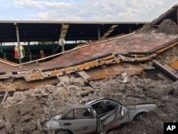 A car sits crushed, engulfed in a pile of rubble from a building felled by a 7.1 earthquake, in Jojutla, Morelos state, Mexico, Sept. 19, 2017.