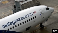 FILE - A Malaysia Airlines staff walks up to a flight prior to departure at the Kuala Lumpur International Airport in Sepang, May 14, 2014. 