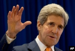 FILE - U.S. Secretary of State John Kerry applauds new Iraqi government.