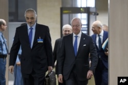 Syrian Ambassador to the U.N. and Head of the Government delegation Bashar al-Jaafari, left, and U.N. Special Envoy for Syria Staffan de Mistura, right, arrive at peace-talks at the U.N. office in Geneva, March 16, 2016.