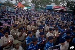 FILE - Indian Central Reserve Police Force soldiers hold candles and pay tribute to their colleagues killed in an attack on a paramilitary convoy in Kashmir, in Hyderabad, India, Feb. 15, 2019.